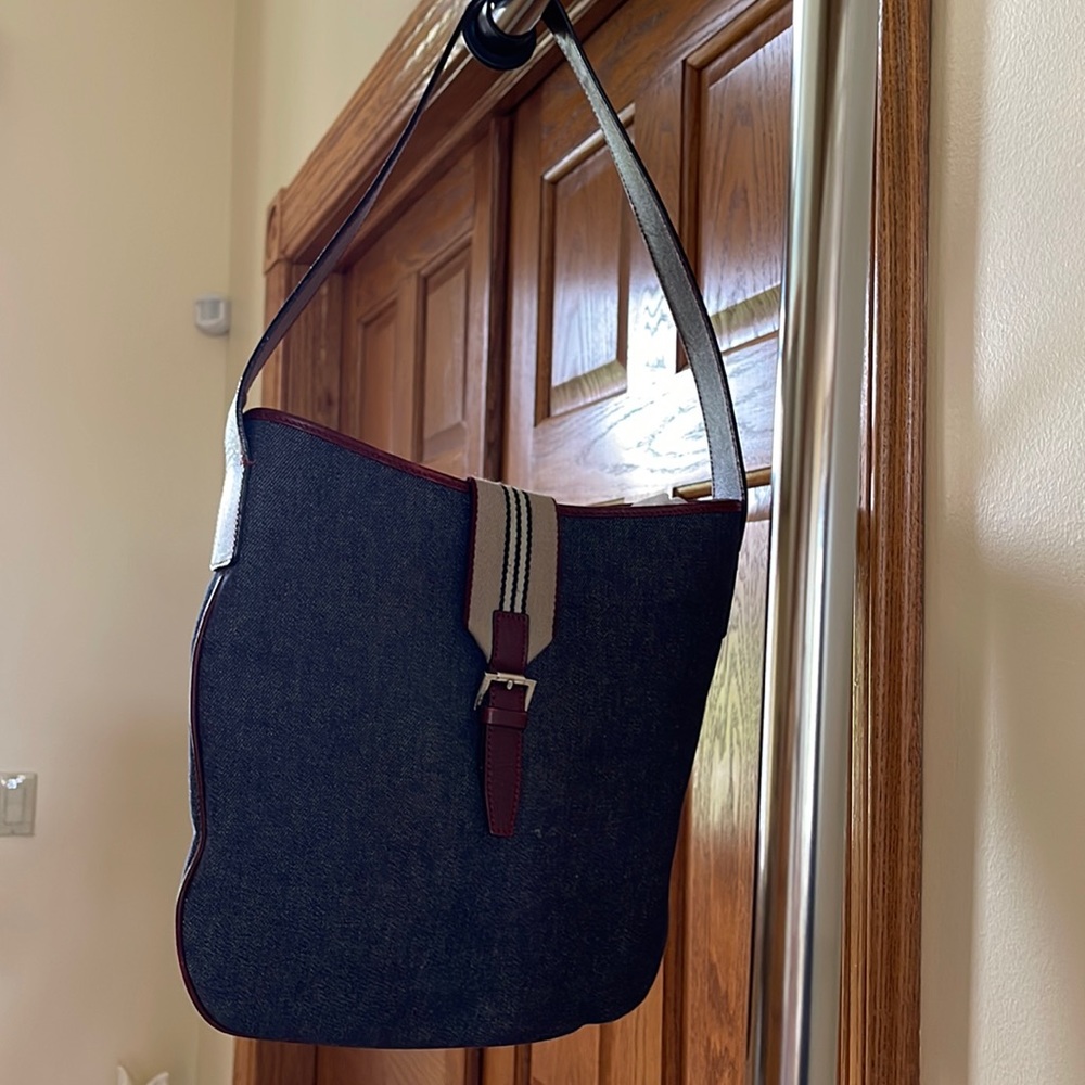 Burberry cute jean bag with burgundy leather strap and part of the buckle.